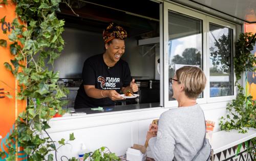 woman in food truck serves another woman food